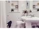 Bright, vintage bathroom with white tiles, pedestal sink and built-in shelving offers a tidy space at 1218 S Josephine St, Denver, CO 80210