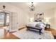 Charming bedroom showcases a decorative chandelier, neutral rug, and ample natural light from the open doorway at 1218 S Josephine St, Denver, CO 80210