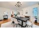 Bright dining room features hardwood floors, a modern chandelier, and seating for six at 1218 S Josephine St, Denver, CO 80210