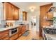 Well-lit kitchen with warm wood cabinets, stainless appliances, and hardwood floors at 1218 S Josephine St, Denver, CO 80210