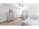 Bright bedroom with carpeted floors, ceiling fan, dresser and vanity with a stool at 13180 Jasmine St, Thornton, CO 80602