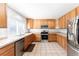 Well-lit kitchen with stainless steel appliances, tile countertops, and ample cabinet space at 13180 Jasmine St, Thornton, CO 80602