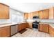 Well-lit kitchen with stainless steel appliances, tile countertops, and ample cabinet space at 13180 Jasmine St, Thornton, CO 80602
