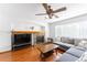 Inviting living room featuring hardwood floors, a brick fireplace, and a comfortable gray sectional couch at 13180 Jasmine St, Thornton, CO 80602
