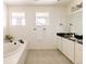 Bright bathroom featuring double sinks, a bathtub, and large windows at 6506 Barnstead Dr, Castle Pines, CO 80108