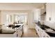 Bright modern kitchen with white cabinets, stainless steel appliances, island with seating, and open to dining area at 6506 Barnstead Dr, Castle Pines, CO 80108
