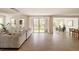 Bright living room with hardwood floors, large windows offering a view of the landscaped backyard, and stylish furniture at 6506 Barnstead Dr, Castle Pines, CO 80108