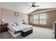This bedroom features a ceiling fan, comfortable bed, carpet, and two windows for natural light at 3699 S Killarney St, Aurora, CO 80013