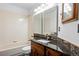 Bathroom featuring vanity with granite counter, double mirrors, and tiled shower at 8725 Meadowlark Cir, Highlands Ranch, CO 80126