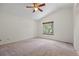 Spacious bedroom offers neutral carpet, ceiling fan, vaulted ceiling, and view to the backyard at 8725 Meadowlark Cir, Highlands Ranch, CO 80126