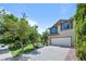Lovely two-story home featuring a two-car garage, green lawn, and mature trees at 8725 Meadowlark Cir, Highlands Ranch, CO 80126