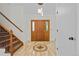 Inviting foyer with tile flooring, a staircase, and a beautiful wooden front door at 8725 Meadowlark Cir, Highlands Ranch, CO 80126