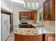 Bright kitchen features wood cabinetry, stainless appliances, granite counters, stylish backsplash, and modern lighting at 8725 Meadowlark Cir, Highlands Ranch, CO 80126
