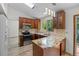 Bright kitchen features wood cabinetry, stainless appliances, granite counters, stylish backsplash, and modern lighting at 8725 Meadowlark Cir, Highlands Ranch, CO 80126