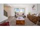 Comfortable living room with a view, featuring a modern sofa, wood accents, and ample natural light at 22092 E 38Th Pl, Aurora, CO 80019