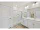 Modern bathroom with a double vanity, large mirror, and glass-enclosed shower at 770 N Deer Park St, Watkins, CO 80137