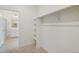 Empty walk-in closet with basic shelving and view into ensuite bath at 770 N Deer Park St, Watkins, CO 80137
