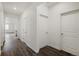 Hallway with dark wood floors and several doors at 770 N Deer Park St, Watkins, CO 80137