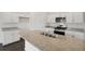 Gorgeous kitchen features white cabinets, island with sink, and stainless appliances at 770 N Deer Park St, Watkins, CO 80137