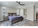 Spacious bedroom with ceiling fan, hardwood floors, ensuite bathroom with sliding barn door, and natural lighting at 6899 Petunia Pl, Castle Rock, CO 80108