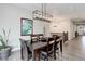 Formal dining room features a rectangular chandelier, wall art, hardwood floors, and staircase views at 6899 Petunia Pl, Castle Rock, CO 80108