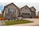 Beautiful home exterior featuring a well manicured lawn, stone accents, and a three car garage at 6899 Petunia Pl, Castle Rock, CO 80108