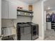 This laundry room features modern appliances, cabinets and shelving for storage, and decorative tile flooring at 6899 Petunia Pl, Castle Rock, CO 80108