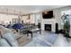 Open-concept living room and kitchen with fireplace, modern appliances, and dark hardwood floors at 6899 Petunia Pl, Castle Rock, CO 80108