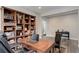 A well-organized home office with hardwood floors, built-in bookcase, and lots of light at 6899 Petunia Pl, Castle Rock, CO 80108