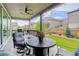 Covered outdoor patio with stylish seating, BBQ grill, string lights, and views of backyard and neighborhood at 6899 Petunia Pl, Castle Rock, CO 80108