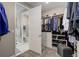 Spacious walk-in closet with custom shelving, carpet, and shoe storage with a bathroom in the background at 6899 Petunia Pl, Castle Rock, CO 80108