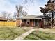 Charming brick home featuring a well-manicured lawn and inviting front porch at 3993 Haddon Rd, Denver, CO 80205