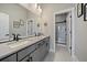 Modern bathroom featuring a double sink vanity with gray cabinets and a glass-enclosed shower at 7010 Homeplace Pt, Castle Rock, CO 80108