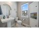 Cozy bathroom showcasing a pedestal sink, decorative mirror, and a storage cabinet with a window view at 7010 Homeplace Pt, Castle Rock, CO 80108