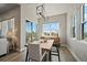 Bright dining room featuring modern light fixture, table, and views through large windows at 7010 Homeplace Pt, Castle Rock, CO 80108