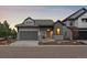 Charming single Gathering home with gray exterior, stone accents, and a two-car garage at 7010 Homeplace Pt, Castle Rock, CO 80108