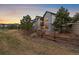 Townhome exterior with well-maintained landscaping and a wooden fence against a colorful sunset sky at 7010 Homeplace Pt, Castle Rock, CO 80108