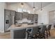 Bright kitchen with gray cabinets, island with seating, and modern lighting fixtures at 7010 Homeplace Pt, Castle Rock, CO 80108