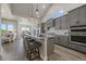 Open concept kitchen with gray cabinets, large island with seating, and stainless steel appliances at 7010 Homeplace Pt, Castle Rock, CO 80108