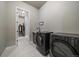 Laundry room equipped with modern, dark appliances and access to a walk-in closet at 7010 Homeplace Pt, Castle Rock, CO 80108