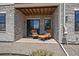 Cozy patio with stone walls, comfortable seating, and a sliding glass door at 7010 Homeplace Pt, Castle Rock, CO 80108