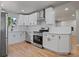Modern white kitchen features stainless steel appliances and light wood floors at 181 E 108Th Ave, Northglenn, CO 80233