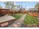 A large backyard with a custom deck, a charming shed, an outdoor swing and stone pathways at 1891 S Madison St, Denver, CO 80210
