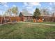Backyard lawn features a swing, storage shed, and outdoor lounge seating area, and a privacy fence at 1891 S Madison St, Denver, CO 80210