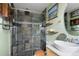 Bathroom featuring a walk-in slate tiled shower, wood shelves, and a vessel sink at 1891 S Madison St, Denver, CO 80210