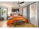 Bright bedroom featuring an orange comforter, wood floors, neutral walls, and stylish decor at 1891 S Madison St, Denver, CO 80210