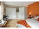 Spacious bedroom features unique accent wall, white closets and doors, and a hardwood floor at 1891 S Madison St, Denver, CO 80210