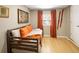 Small bedroom features a wood daybed with orange pillows and a rustic wood accent wall hanging at 1891 S Madison St, Denver, CO 80210