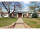 Charming single-story home with stone accents, shutters, landscaping, and welcoming walkway at 1891 S Madison St, Denver, CO 80210