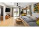 Bright living room with a comfortable gray sofa, skylight, ceiling fan, and sliding door to backyard at 1891 S Madison St, Denver, CO 80210